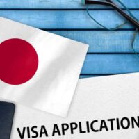 日本の国旗とパスポート、ビザ申請用紙のイメージ